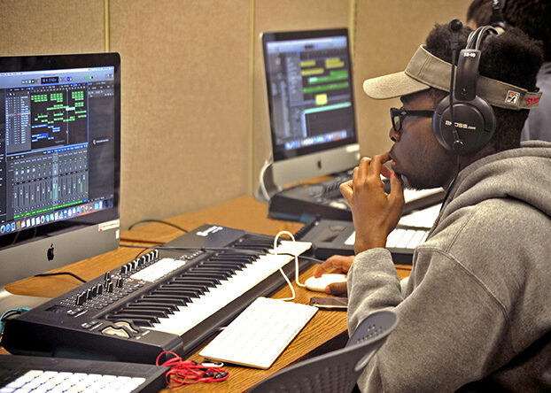 Image of a student working on a digital audio workstation in a computer lab.