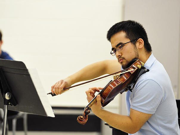 A violin student performs during a recital. 