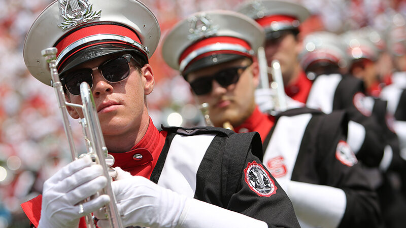 Close-up image of a line of marching band trumpeters.