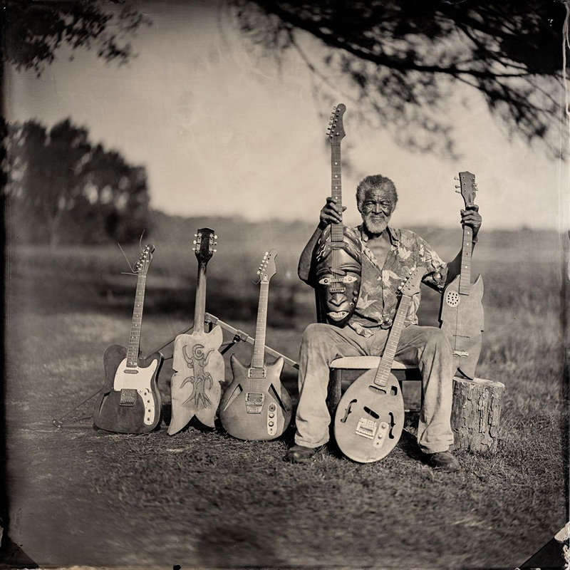 Tintype photo of Freeman Vines surrounded by his guitars