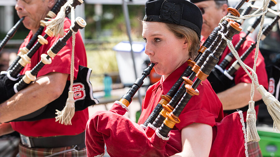 Image of a bagpipe player with other bagpipers in the background.