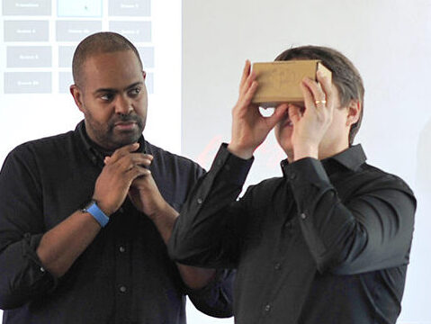 Dr. Derek Ham shows Dr. Peter Askim how to use a VR headset.