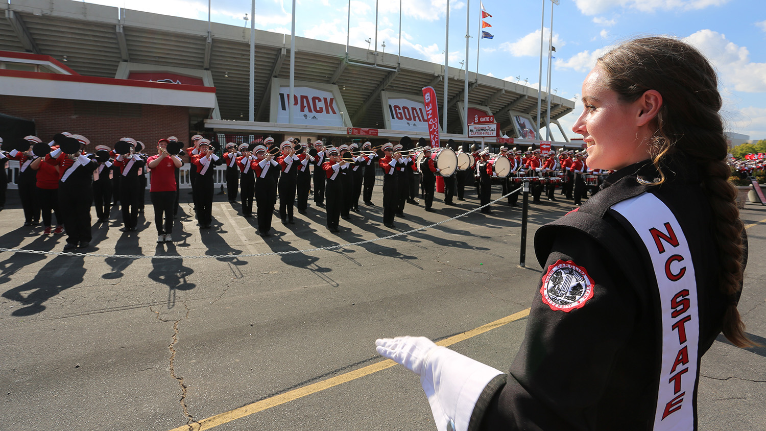 Laura Dugan faces the marching band with hands raised to conduct