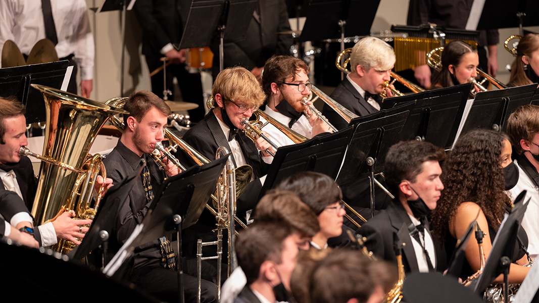 Musicians play brass instruments during a symphonic band concert