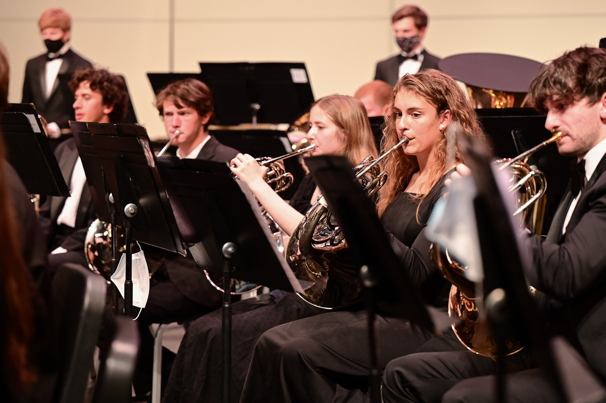 Students play french horns during a wind ensemble concert