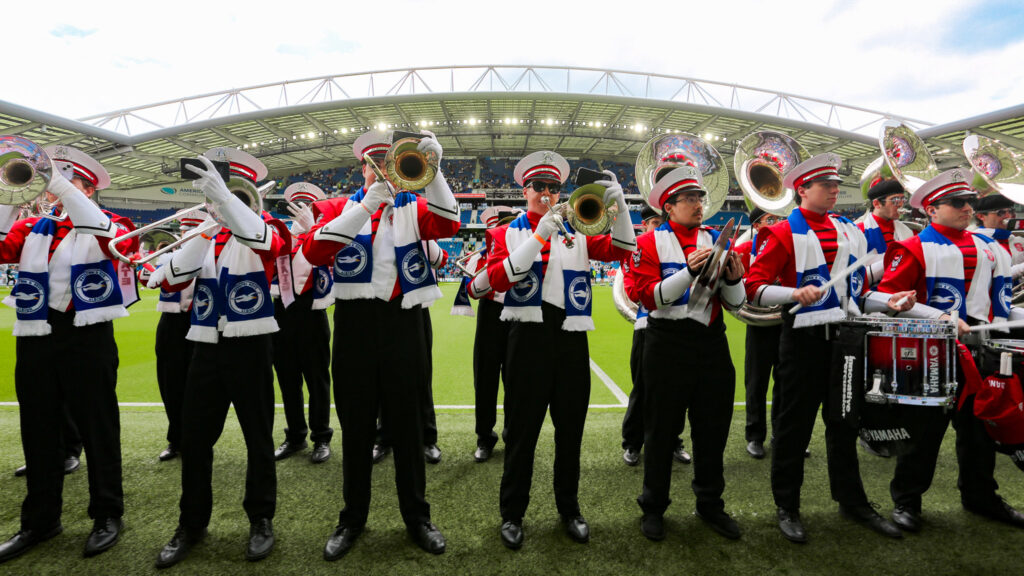 Marching Band perform at a soccer stadium.