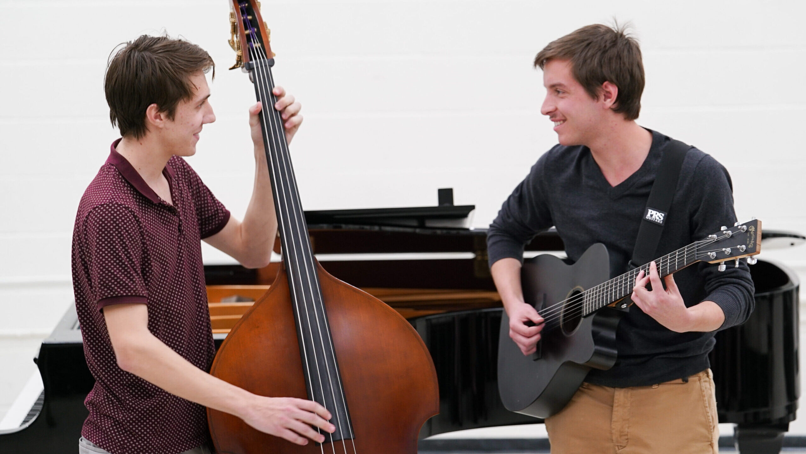 Two students smile at each other as they perform together.