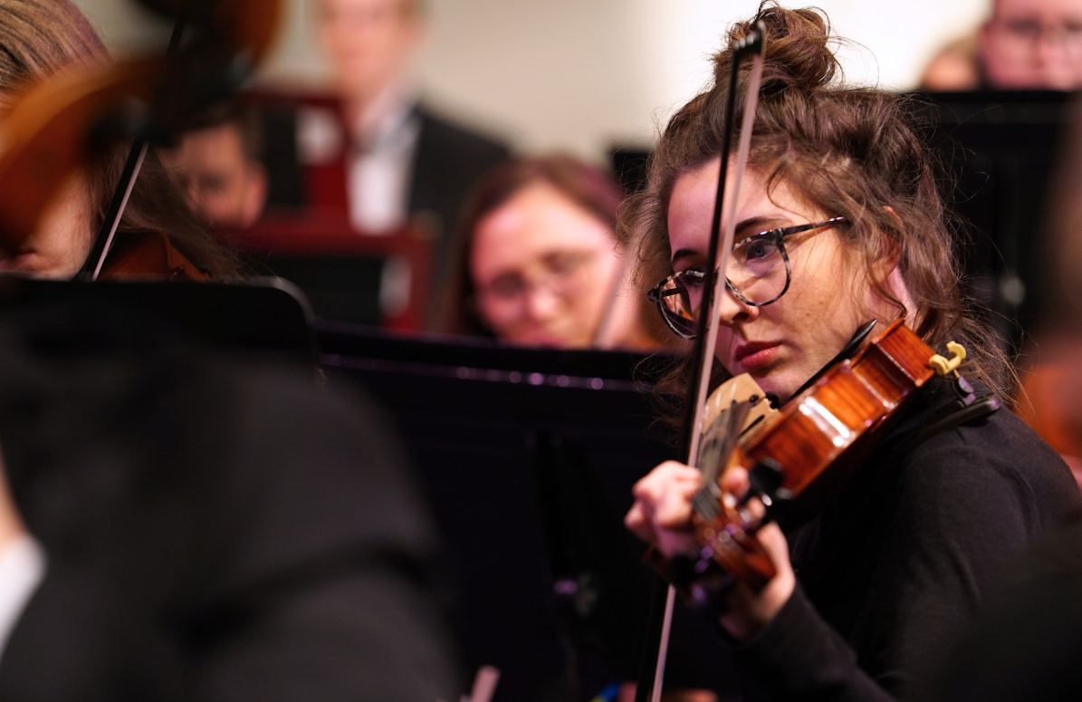 Student plays violin during a concert performance.