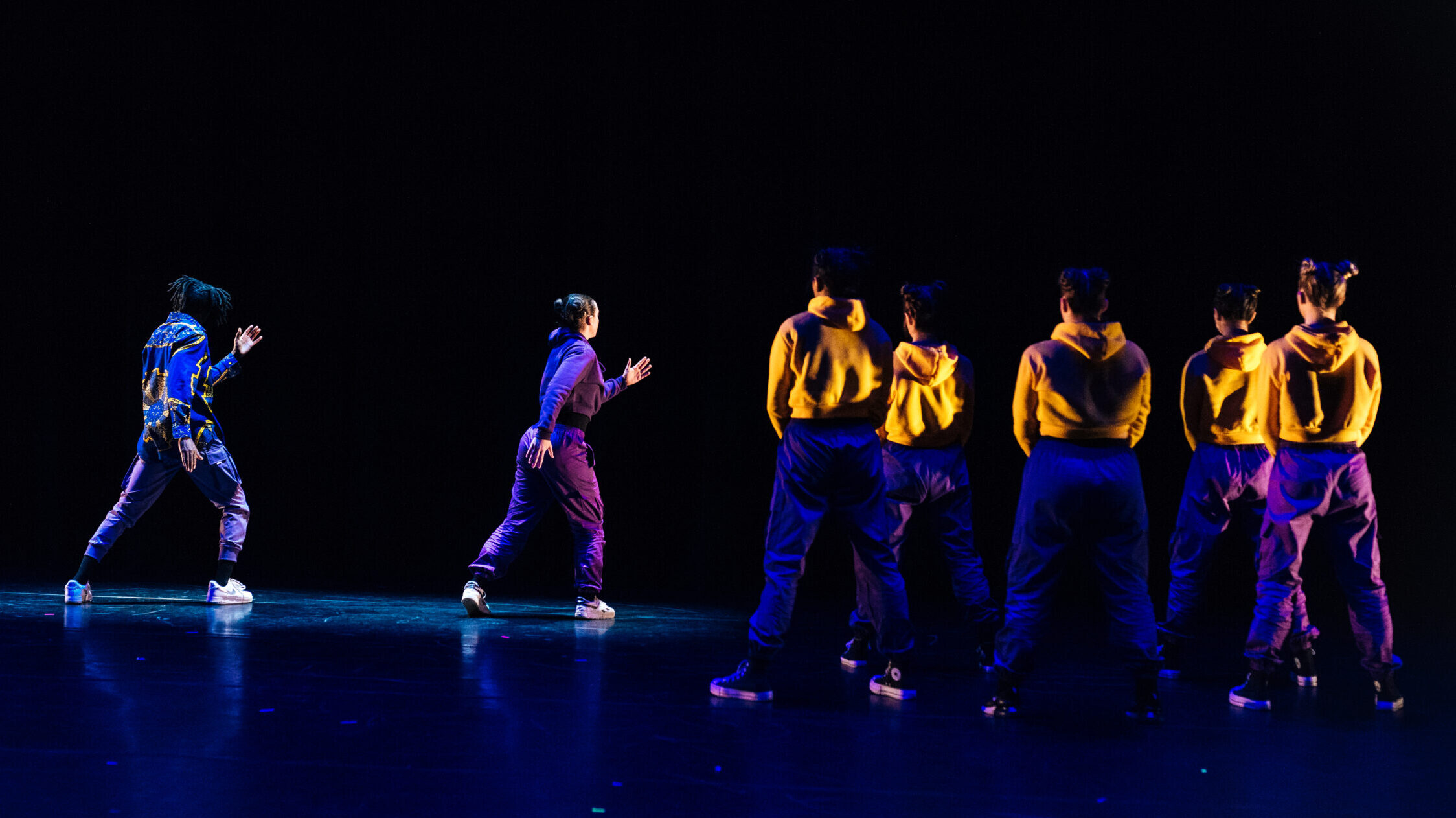 A group of dancers perform on stage together.