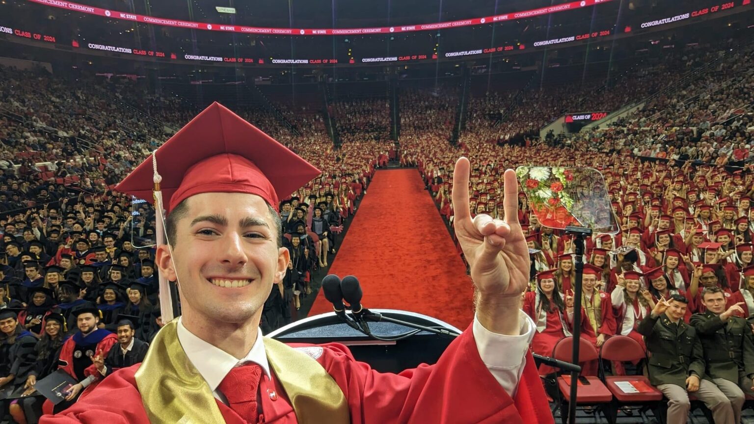 Ben Poovey poses for selfie with NC State's Spring 2024 Commencement attendees at PNC Arena